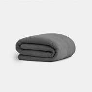 A Cocoon Cotton Duvet Cover in dark gray with a textured finish, neatly folded on a plain white background.