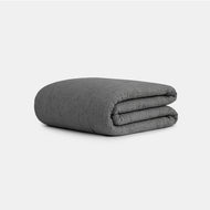 The Cocoon Cotton Quilt Set, featuring a neatly folded dark gray textured design, is displayed on a plain light gray background.