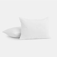The Cocoon Cotton Quilted Sham Set is displayed on a plain white background; one sham stands upright facing forward, while the other lies flat behind it. Both feature a subtle grid-like quilted texture.