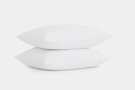 Two clean, white Cotton Percale Pillowcase Set pillows stacked on top of each other against a plain white background.