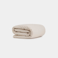 The Cotton Percale Duvet Cover, in light beige, is neatly folded and displayed against a clean white background.