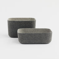 Two rectangular Felt Bins in dark grey with light grey interiors are displayed on a white surface, with one bin positioned slightly ahead of and below the other.