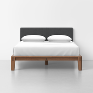 The Classic Bed - Combined Listing features a modern wooden frame, dark gray upholstered headboard, white bedding, and two white pillows, set against a plain white wall and floor.