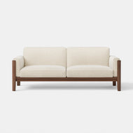 The Classic Sofa, featuring cream-colored cushions and a wooden frame, is shown from the front against a plain white background.