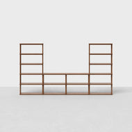 The Pillar Media Center is a modern, U-shaped wooden shelving unit with open shelves, showcased on a light-colored floor against a plain white background.