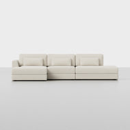 The Signature Island Chaise Sectional is a modern, light beige sofa featuring three seat cushions, three back cushions, and three matching rectangular pillows, displayed against a plain white background.