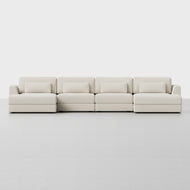The Signature U Chaise Sectional is a modern, light beige four-seat sofa with matching rectangular pillows, shown against a plain white background.