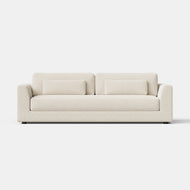 The Signature Sofa, 96″, is a modern, cream-colored piece featuring two seat cushions, two rectangular back cushions, and two matching bolster pillows, displayed against a plain white background.