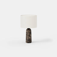The Stone Table Lamp features a cylindrical white fabric shade and a dark marbled stone base, displayed against a plain white background.